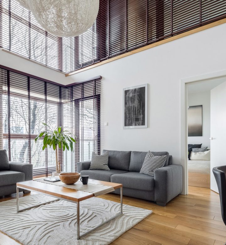A modern living room with high ceilings, large windows, and minimalist decor, creating a bright and airy space.