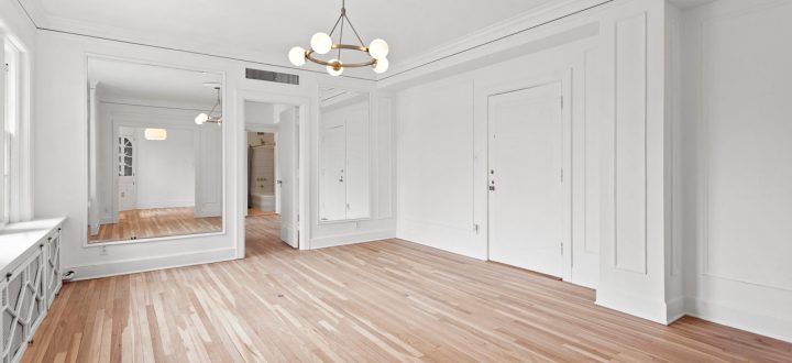 Bright and spacious interior of a home with light hardwood flooring, white walls, and elegant molding details, perfect for showcasing interior painting results.