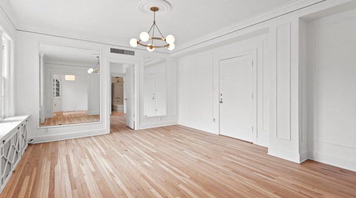 Bright and spacious interior of a home with light hardwood flooring, white walls, and elegant molding details, perfect for showcasing interior painting results.