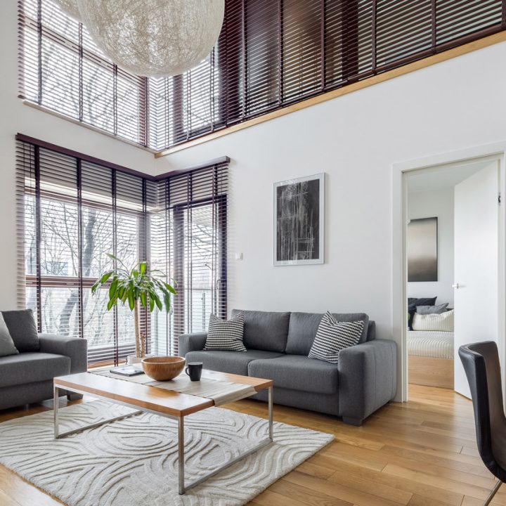A modern living room with high ceilings, large windows, and minimalist decor, creating a bright and airy space.