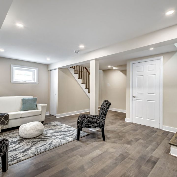 A stylishly remodeled basement with contemporary furniture and decorative accents, showcasing a comfortable and modern aesthetic.